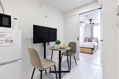 a small room with a table and chairs and a bed at \u30aa\u30fc\u30af\u30d6\u30e9\u30f3\u30ab\u5e61\u30f6\u8c37 in Tokyo