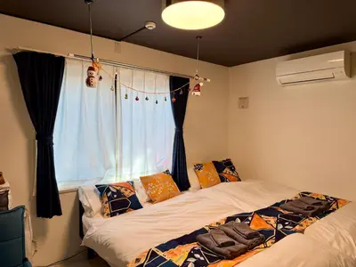 a bedroom with two beds in front of a window at Yoyogi Park Retreat in Tokyo