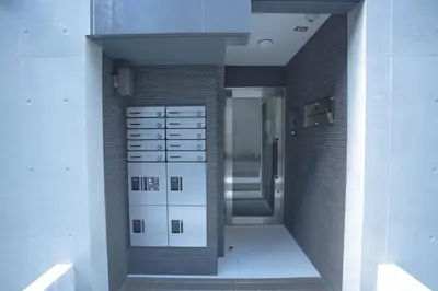 a hallway of a building with white cabinets and a door at Yoyogi Park Retreat in Tokyo