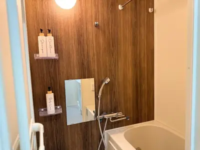 a bathroom with a mirror and a tub and a sink at Yoyogi Park Retreat in Tokyo