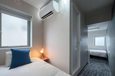 a bedroom with a bed with a blue pillow and a window at Nishisugamo hotel-TS0443 in Tokyo
