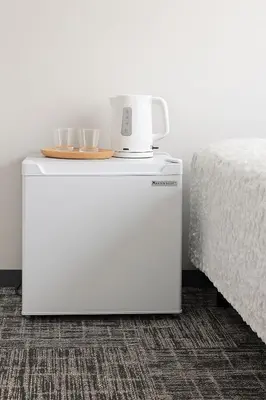 a small white refrigerator next to a bed at Nishisugamo hotel-TS0443 in Tokyo