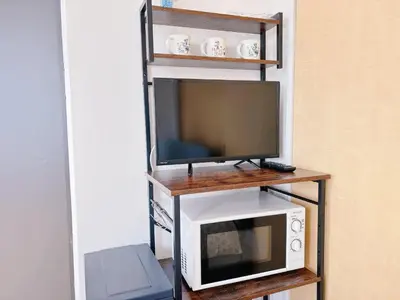 a television and a microwave on a shelf at 501, Near Shinjuku, JR Sobu Line, Elevator available, \u65b0\u5bbf\u7ad92\u7ad9\u53ef\u8fbe,\u79cb\u53f6\u539f \u516d\u672c\u6728 \u4e0a\u91ce \u7b51\u5730\u5e02\u573a\u53ef\u76f4\u8fbe,\u6709\u7535\u68af,3\u6761\u5730\u94c1\u53ef\u7528 in Tokyo