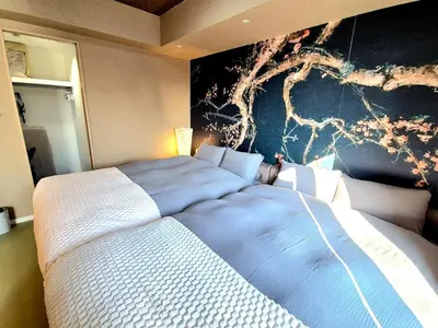 a bedroom with a large bed with a painting on the wall at shibuya square 11F Shibuya Scramble Crossing near in Tokyo