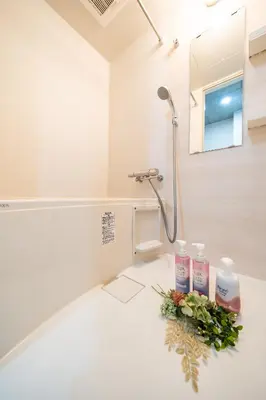 a bathroom with two bottles of soap and flowers at \uff48\uff44\uff43\u5927\u585a in Tokyo