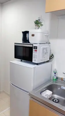 a microwave sitting on top of a refrigerator at \uff48\uff44\uff43\u5927\u585a in Tokyo