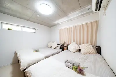two beds in a room with white walls at \uff48\uff44\uff43\u5927\u585a in Tokyo