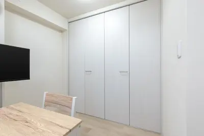 a room with white cabinets and a table and a chair at \u304b\u3064\u3089303 in Tokyo