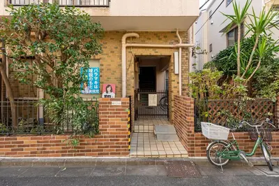 a bike parked in front of a brick house at \u304b\u3064\u3089303 in Tokyo