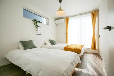 two beds in a room with a window at SCD2 Ikebukuro Commercial District Premium Homestay in Tokyo