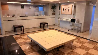 a waiting room with a table and two stools at \u30db\u30c6\u30eb\u30b5\u30fc\u30d6\u6e0b\u8c37 in Tokyo