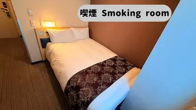 a hotel room with a bed with a smoking room sign at \u30db\u30c6\u30eb\u30b5\u30fc\u30d6\u6e0b\u8c37 in Tokyo
