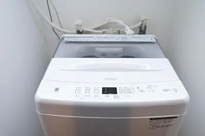 a washing machine in a room with a wall at Evergreen hotel ichigaya in Tokyo
