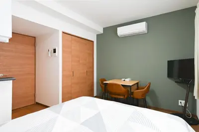 a bedroom with a bed and a table with chairs at Evergreen hotel ichigaya in Tokyo