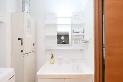 a white bathroom with a sink and a mirror at Evergreen hotel ichigaya in Tokyo