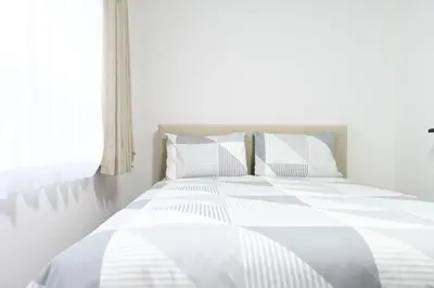 a white bed with white sheets and pillows at Evergreen hotel ichigaya in Tokyo
