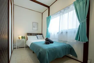 a bedroom with a bed and a large window at M&T stay in Tokyo