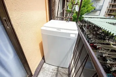 a washing machine sitting on the side of a building at M&T stay in Tokyo