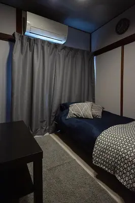 a small bedroom with a bed and a window at M&T stay in Tokyo