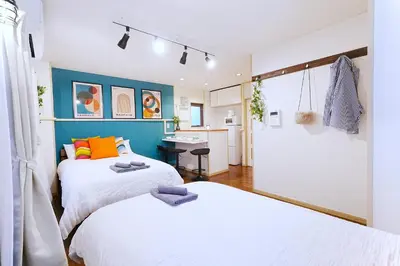 a bedroom with two beds and a desk in it at HIKA HOUSE Shinkoiwa in Tokyo