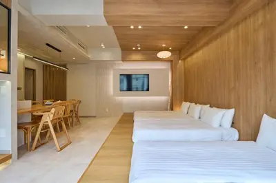 a hotel room with two beds and a table at STAY ARI Arakicho B in Tokyo