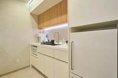 a kitchen with white cabinets and a refrigerator at STAY ARI Arakicho B in Tokyo