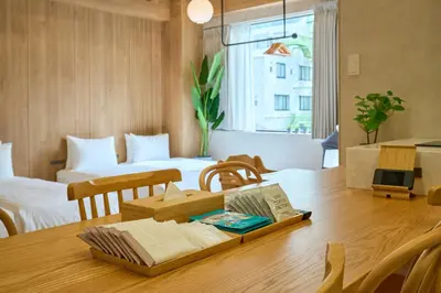a room with a wooden table with two beds at STAY ARI Arakicho B in Tokyo