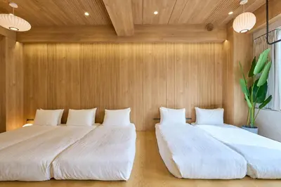 two beds in a room with wooden walls at STAY ARI Arakicho B in Tokyo