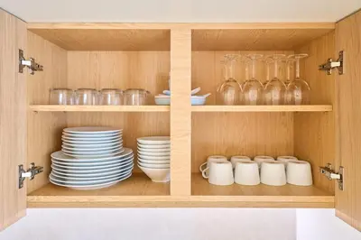 a cupboard with plates and glasses and dishes at STAY ARI Arakicho B in Tokyo