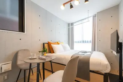 a bedroom with a bed and a small table with a table at \u30a2\u30fc\u30d9\u30a4\u30f3\u8981\u753a in Tokyo