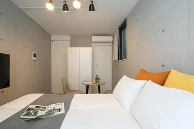a bedroom with a white bed and a table at \u30a2\u30fc\u30d9\u30a4\u30f3\u8981\u753a in Tokyo
