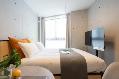 a bedroom with a bed with a tv on the wall at \u30a2\u30fc\u30d9\u30a4\u30f3\u8981\u753a in Tokyo