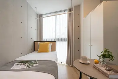 a bedroom with a bed and a table and a window at \u30a2\u30fc\u30d9\u30a4\u30f3\u8981\u753a in Tokyo