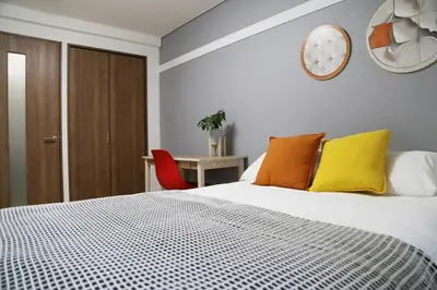a bedroom with a bed and a clock on the wall at Pr22 \u4e0b\u843d\u5408 in Tokyo