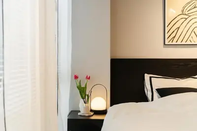 a bedroom with a bed and flowers on a nightstand at 7minute walk from JR Takadanobaba Station, 11 minutes from Shinjuku ,Wi-Fi, simple and high-quality space in Tokyo
