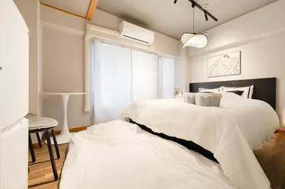 a bedroom with a large white bed and a window at 7minute walk from JR Takadanobaba Station, 11 minutes from Shinjuku ,Wi-Fi, simple and high-quality space in Tokyo