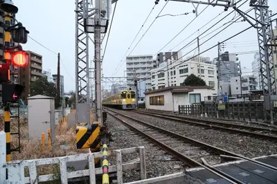a yellow train is coming down the tracks at Pr31\u4e0b\u843d\u5408 in Tokyo