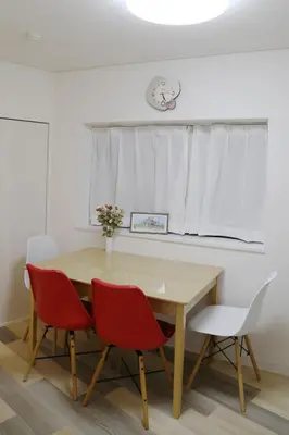 a dining room table with red chairs and a white curtain at Pr31\u4e0b\u843d\u5408 in Tokyo