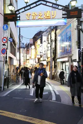 a man walking down a street in a city at Pr32 \u4e0b\u843d\u5408 in Tokyo