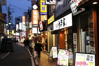 a group of people walking down a city street with signs at Pr33\u4e0b\u843d\u5408 in Tokyo