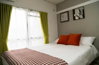 a bedroom with a bed with orange pillows and a window at Pr33\u4e0b\u843d\u5408 in Tokyo
