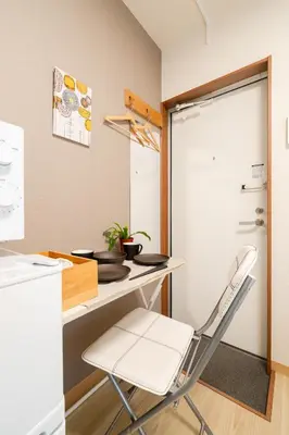 a small kitchen with a table and a chair at Parkside Shinjuku Tokyo in Tokyo