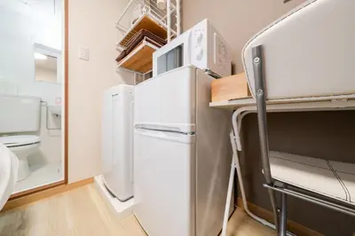 a kitchen with a refrigerator and a microwave at Parkside Shinjuku Tokyo in Tokyo
