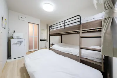 a bedroom with two bunk beds and a window at Parkside Shinjuku Tokyo in Tokyo