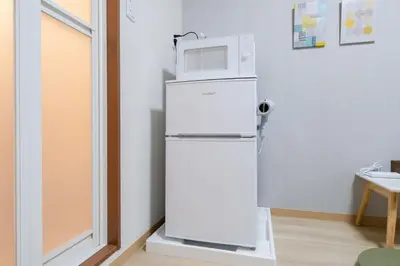 a white refrigerator with a microwave on top of it at Parkside Shinjuku Tokyo in Tokyo