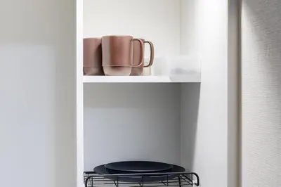a shelf with cups and a stool in a closet at Parkside Shinjuku Tokyo in Tokyo