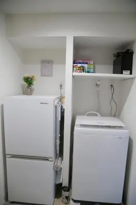 a small kitchen with a refrigerator and a shelf at Pr34\u4e0b\u843d\u5408 in Tokyo