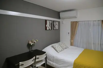 a bedroom with a bed and a table with a vase of flowers at Pr34\u4e0b\u843d\u5408 in Tokyo