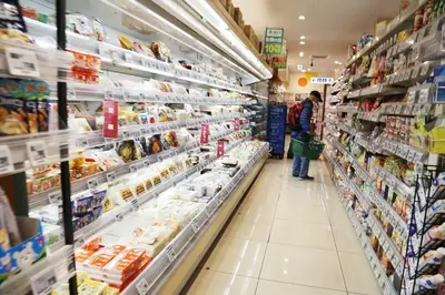 a grocery store aisle with a person standing in the aisle at Pr36\u4e0b\u843d\u5408 in Tokyo