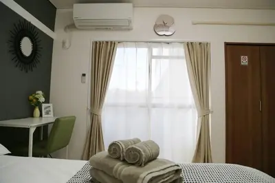 a bedroom with a bed and a window with towels at Pr36\u4e0b\u843d\u5408 in Tokyo